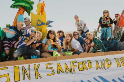 6th graders smile for the camera from their float for Homecoming parade