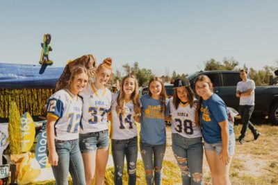 simla students smile for the camera in field by their float