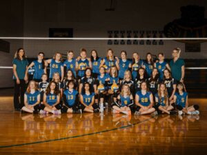 2023 junior high volleyball team poses for team picture in gym